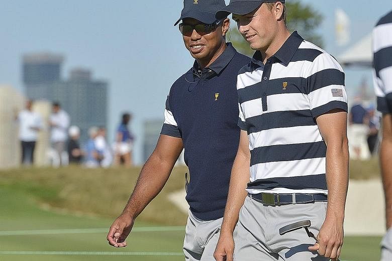From top: Adam Scott tees off on the 10th hole at the Liberty National Golf Course, which offers views of the Manhattan skyline. US team golfer Jordan Spieth talking with assistant captain Tiger Woods (far left) during the Presidents Cup. Spieth, 24,
