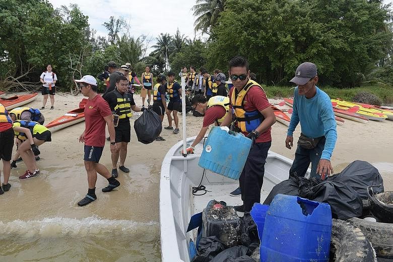 Some of the 100 or so volunteers who spent three hours collecting trash between Sembawang Beach and Seletar Island yesterday. The Clean-Up on Kayak event was organised by the MPA.