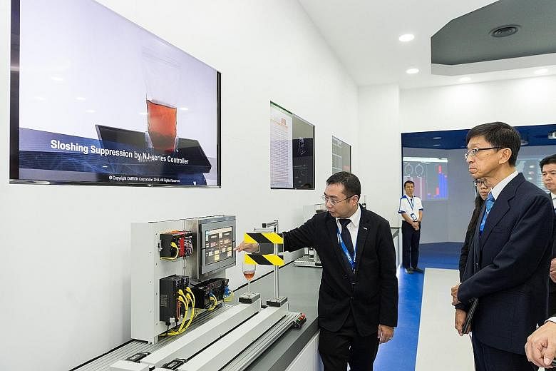 Professor Quek Tong Boon (right), CEO of the National Robotics Programme, at a product demonstration at Omron Automation Centre.