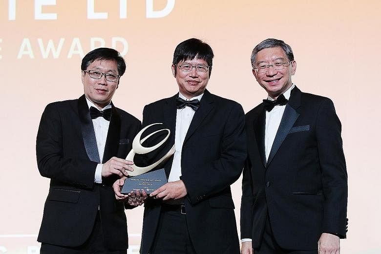 Managing director Tian Xianyong (centre) of Ace Water, one of the winners of the Emerging Enterprise 2017 Award, being presented the trophy by Business Times editor Wong Wei Kong (far left) and Mr Linus Goh, OCBC's global commercial banking head.
