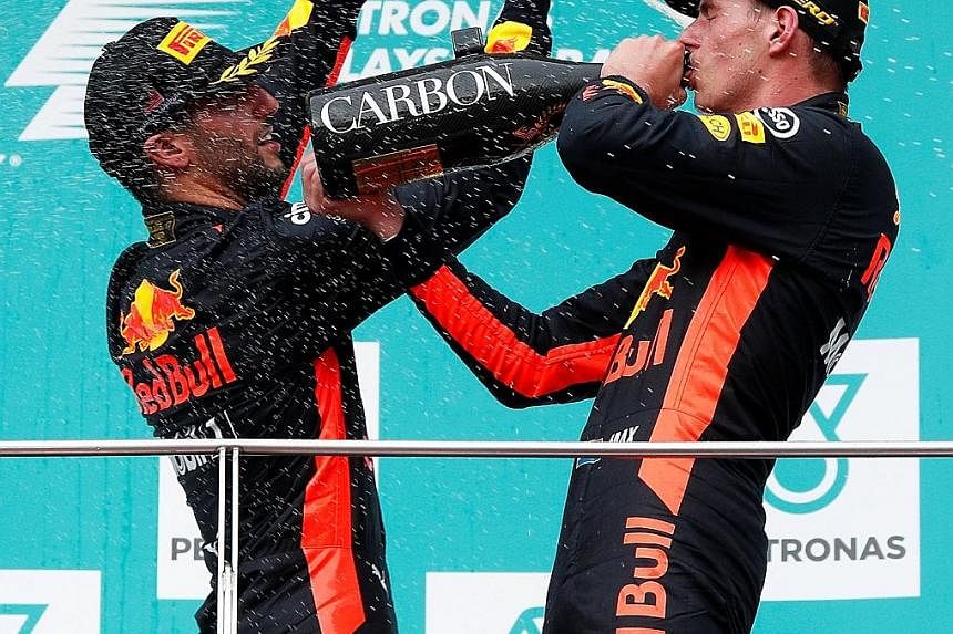 Red Bull team-mates Max Verstappen (right) and Daniel Ricciardo celebrate on the podium after their 1-3 finish.