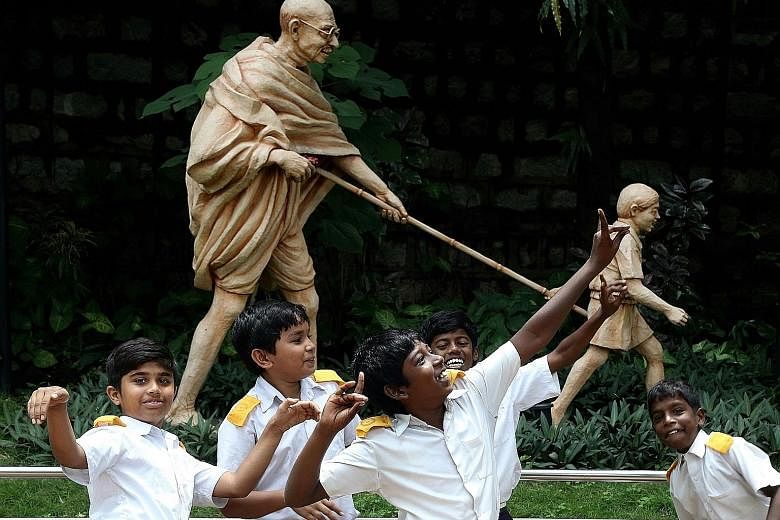 Indian students in Bangalore celebrating in front of a statue of Mahatma Gandhi on his 148th birth anniversary yesterday. Mohandas Karamchand Gandhi, also known as Bapu or Father of the Nation, was born on Oct 2, 1869, in Porbandar, Gujarat. He studi