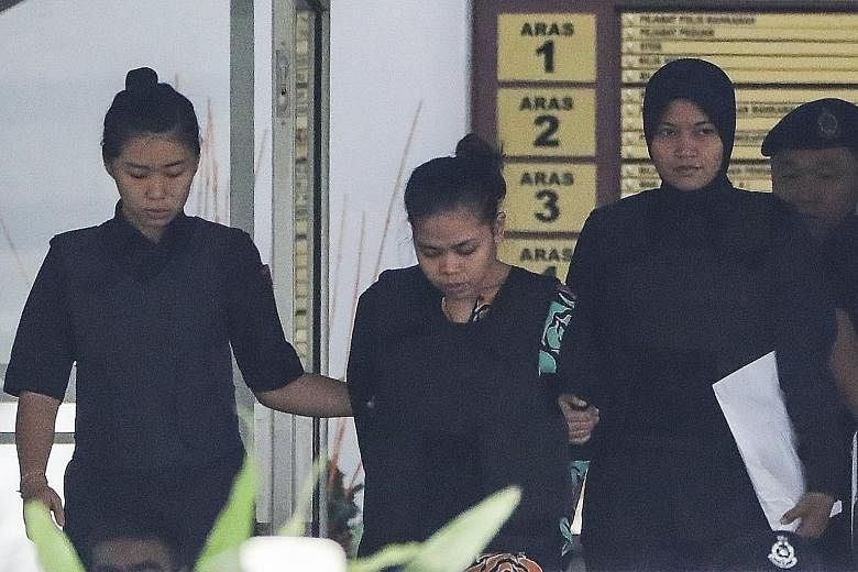 Indonesian Siti Aisyah (left) and Vietnamese Doan Thi Huong being escorted by police at the High Court in Shah Alam yesterday. Both face the death penalty if found guilty of Mr Kim Jong Nam's murder.