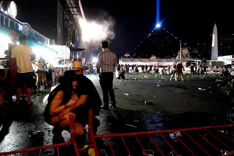 Concert-goers at the Las Vegas festival venue. The bursts of gunfire sent people running for their lives and sparked confusion. Far left: People carrying an injured person to safety after gunfire broke out at the Route 91 Harvest country music festiv