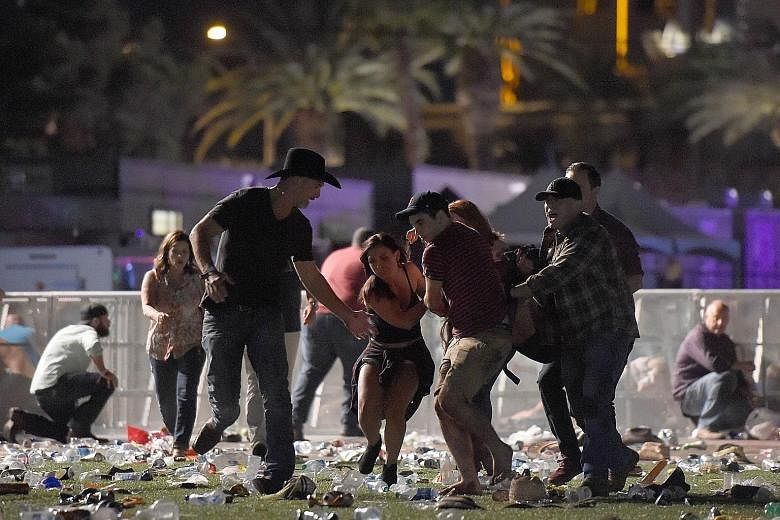 Concert-goers at the Las Vegas festival venue. The bursts of gunfire sent people running for their lives and sparked confusion. Far left: People carrying an injured person to safety after gunfire broke out at the Route 91 Harvest country music festiv