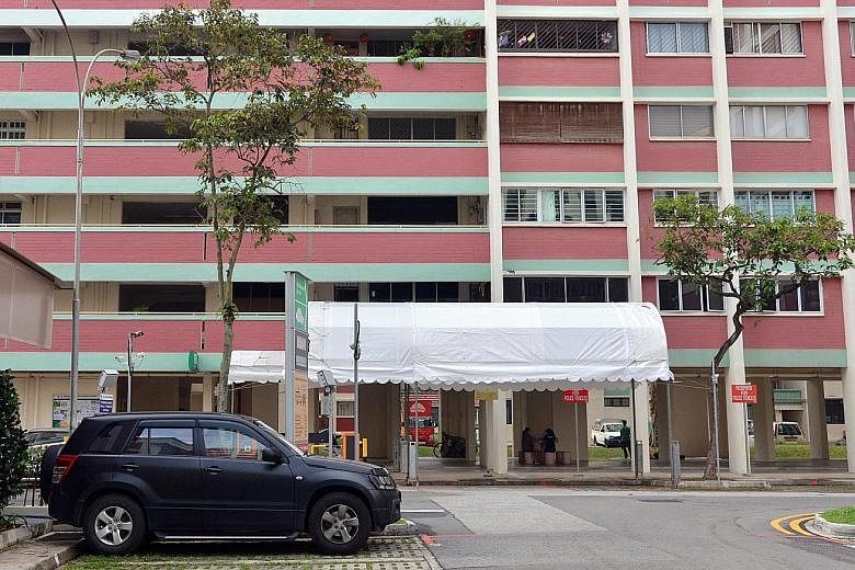 Above: An awning was put up at the foot of the HDB block where President Halimah Yacob lives. Left: Madam Halimah and her husband, Mr Mohamed Abdullah Alhabshee, leaving their Yishun flat on Sept 13.