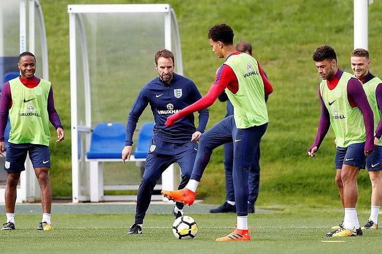 England manager Gareth Southgate enjoying a kick-about in training with members of his squad ahead of tomorrow's World Cup qualifier against Slovenia at Wembley. Midfielder Dele Alli (front) will play no part, having copped a one-match ban for his vu