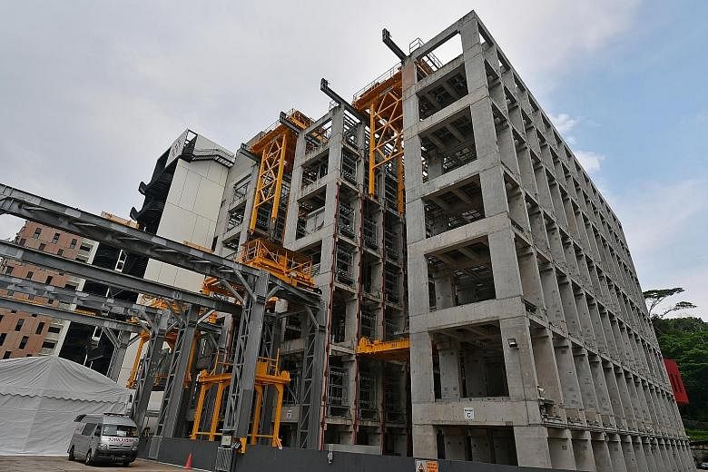An automated precast storage facility at the integrated construction and prefabrication hub, Greyform Building, in Kaki Bukit. Such hubs optimise land use and require less time and fewer workers to build. Minister for Finance Heng Swee Keat viewing t