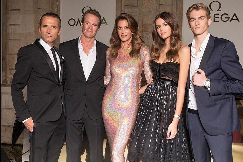 Cindy Crawford (centre) with (from far left) Mr Raynald Aeschlimann, president and chief executive officer of Omega, husband Rande Gerber, daughter Kaia and son Presley at the opening of the Her Time exhibition in Paris recently.