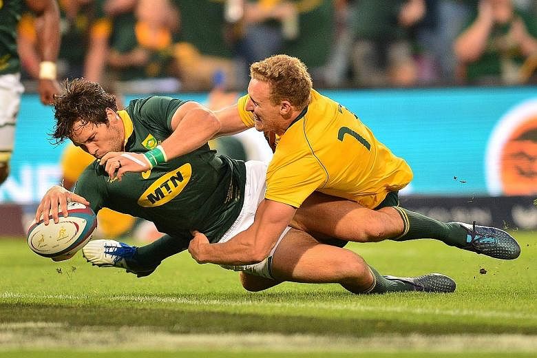 South Africa's Jan Serfontein muscling his way past Australia's Reece Hodge to score a try during the Rugby Championship match in Bloemfontein, South Africa last week. The Springboks were held to a 27-27 draw and will next face the All Blacks on Satu