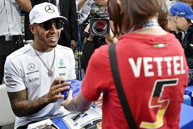 Clockwise from far left: This supporter of former F1 driver Robert Kubica, Ferrari's Kimi Raikkonen and McLaren's Fernando Alonso is clearly no fair-weather fan. Mercedes driver Lewis Hamilton does not sign out when a Sebastian Vettel fan asks for hi