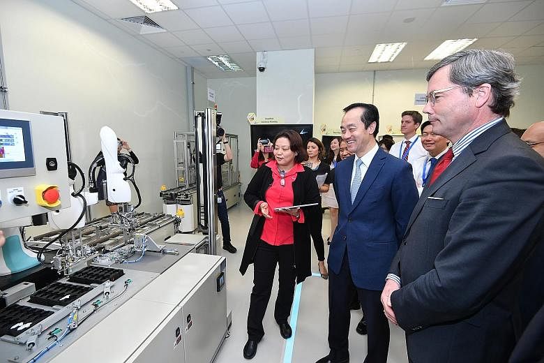 Senior Minister of State for Trade and Industry and National Development Koh Poh Koon (centre) with German Ambassador Ulrich Sante (right) at the A*Star model factory located in one-north. They are viewing some of the equipment which manufacturers ca