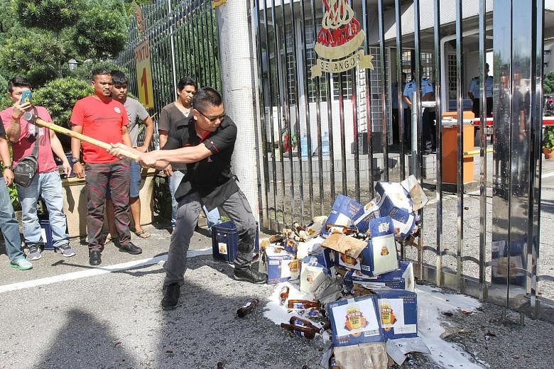 Datuk Seri Jamal Yunos smashing beer bottles on Thursday.