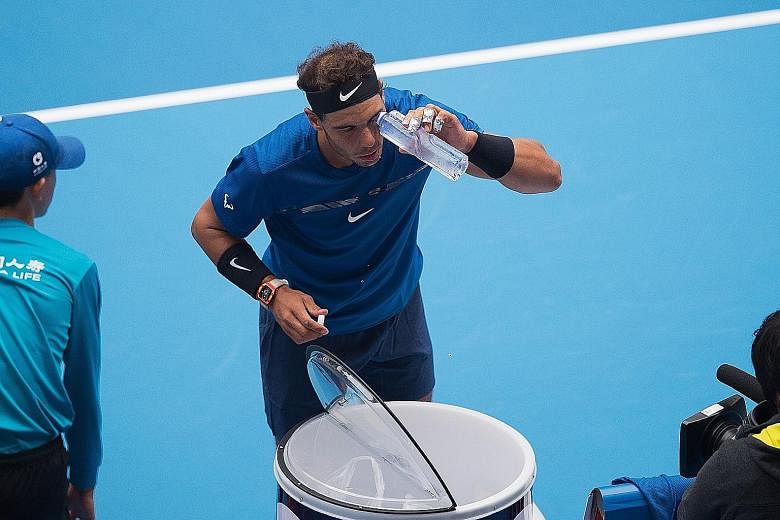 Rafael Nadal of Spain washing his eye with water during his quarter-final against the American John Isner at the China Open in Beijing yesterday. It did not delay victory too much as he set up a semi-final against Grigor Dimitrov.