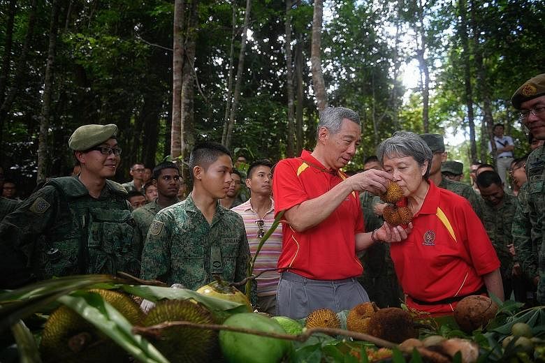 Prime Minister Lee Hsien Loong and Mrs Lee being shown various fruits that soldiers learn to survive on during the jungle training at Temburong in Brunei. Accompanying them was Chief of Army Melvyn Ong (right).