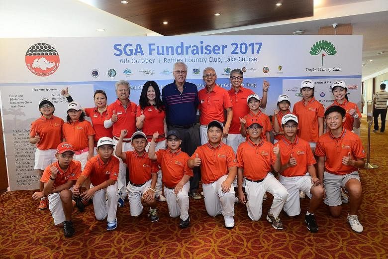 Emeritus Senior Minister Goh Chok Tong (in blue) with Singapore Golf Association (SGA) board members and young golfers from the national junior squad during the SGA's annual fund-raiser at Raffles Country Club on Friday. He was the guest of honour fo