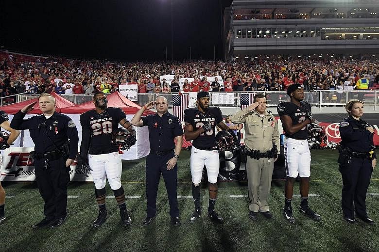 Policemen singing the national anthem with American football players at the Sam Boyd Stadium in Las Vegas last Saturday night in honour of victims of the deadliest mass shooting in modern US history.