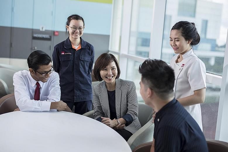 ITE chief executive Low Khah Gek (centre) with some of the school’s students. She believes its ability to respond swiftly to industry changes and provide effective hands-on learning places it in a unique position to train adults who are keen to upgrade th