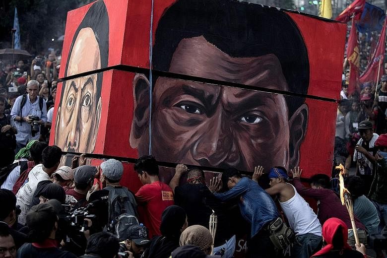 Activists preparing to burn a structure bearing the image of Philippine President Rodrigo Duterte during a protest against near Malacanang Palace in Manila on Sept 21. One reason his popularity is at its lowest since he took office in June last year 