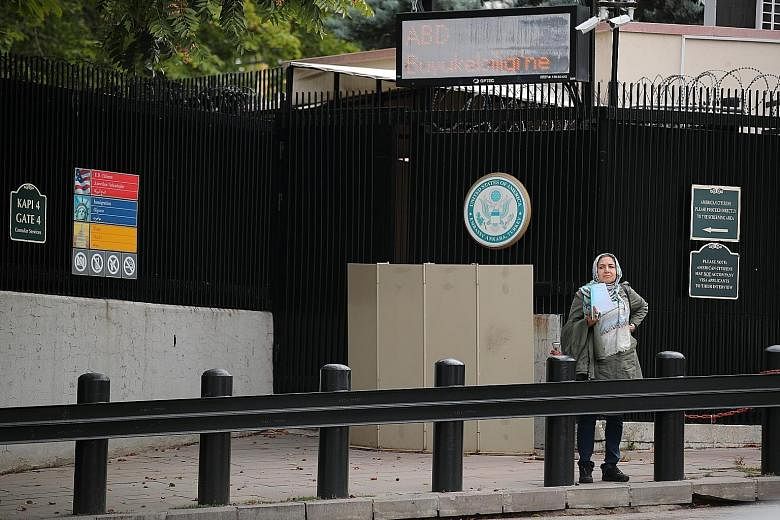 A woman waiting in front of the visa application office entrance of the United States Embassy in Ankara yesterday. The US has stopped visa services at all its missions in Turkey. Ankara yesterday summoned the US Embassy's deputy chief of mission, Mr 