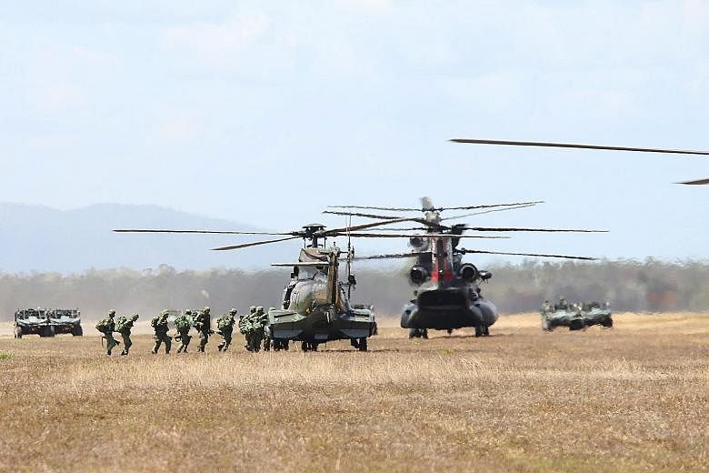 Servicemen boarding a Super Puma helicopter during a troop lift operation at their pick-up point in Exercise Wallaby, which has been held yearly since 1990. This year's exercise involved around 4,000 SAF personnel. Second Minister for Defence Ong Ye 