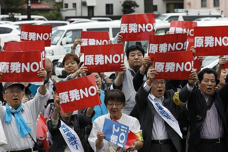Plaintiffs hold up banners reading "No Nuclear Power Plant", before winning their class action suit at the Fukushima district court yesterday.