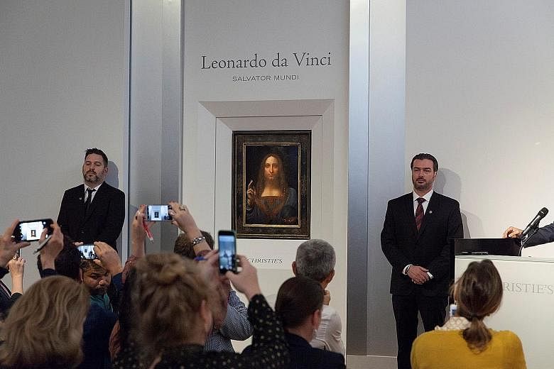 Leonardo da Vinci's Christ As Salvator Mundi (left) on display at Christie's in New York and Andy Warhol's Sixty Last Suppers (below).