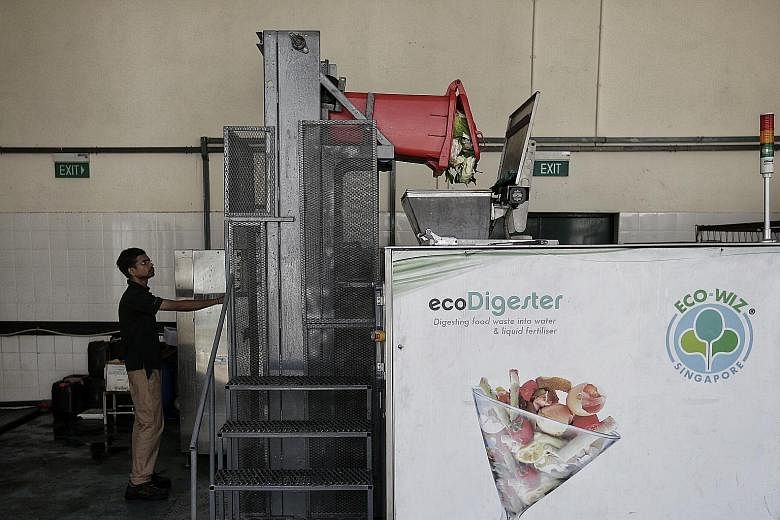 Bins for food waste at the market and food centre at Block 628 in Ang Mo Kio Avenue 4. The pilot of a food digester here has "performed according to expectations", said the National Environment Agency. The food digester in operation at Block 628 in A