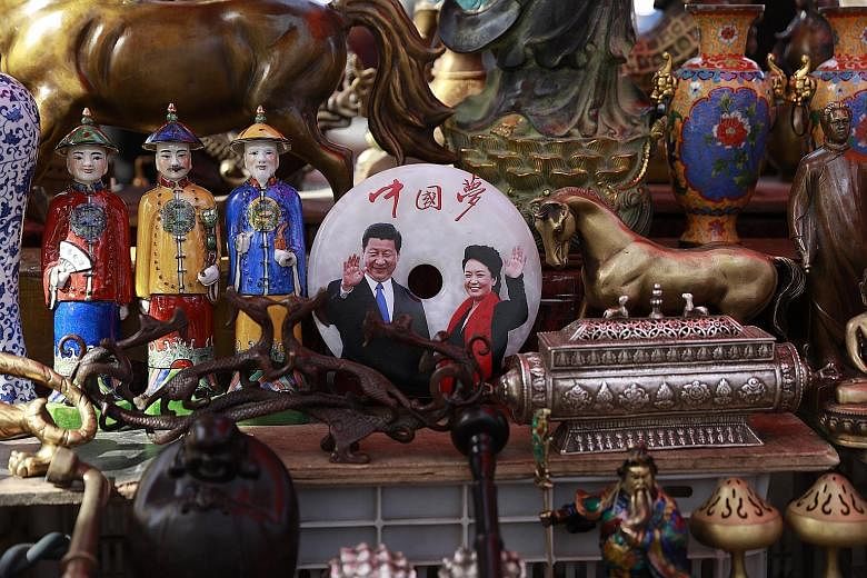 A jade plaque engraved with a picture of Chinese President Xi Jinping and his wife Peng Liyuan with the words "China Dream" on display at a stall in the Panjiayuan Antique market in Beijing yesterday.
