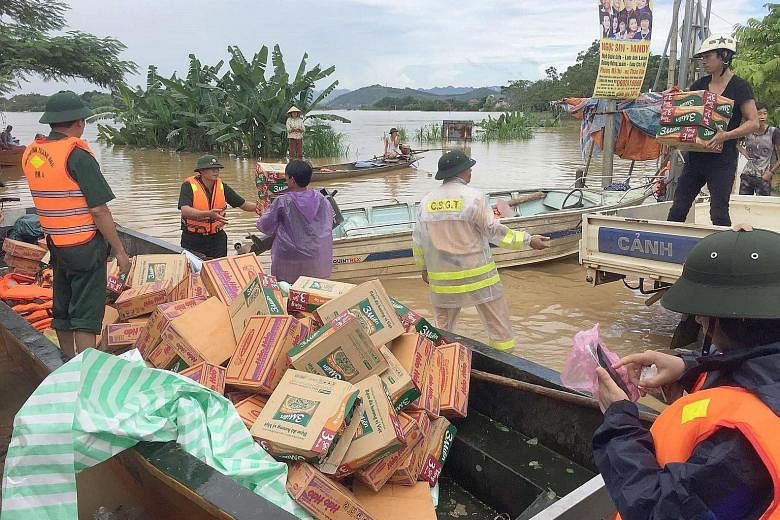Rescuers load boats with boxes of food, mostly instant noodles, that will be distributed to local residents in Thach Thanh district, in the central province of Thanh Hoa, yesterday. Northern Hoa Binh is the hardest-hit region, with 11 dead and 21 mis