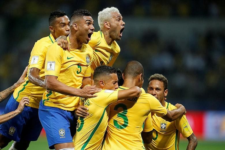 Brazil's players celebrating their first goal in the 3-0 win over Chile in Sao Paulo on Tuesday, a result that enabled them to top the South American qualifying group and which knocked the visitors out. The Selecao have won 10 and drawn two of their 