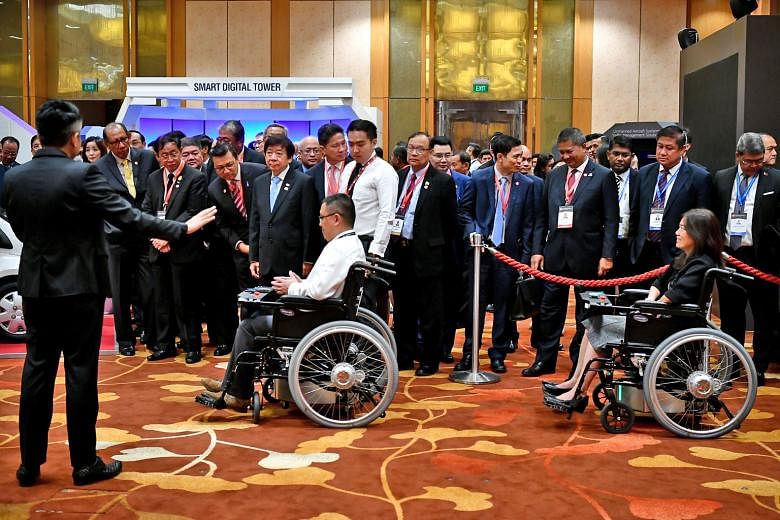 Coordinating Minister for Infrastructure and Transport Minister Khaw Boon Wan and Asean transport ministers checking out the Smart Wheelchair System, which uses visual markers for the wheelchairs to move in a convoy autonomously, at the Future of Tra