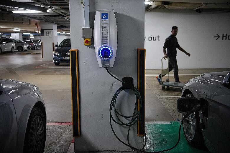 Left: The 330e iPerformance is equally driveable in electric and petrol mode. Above: A charging station for the car at Galaxis Building, 1 Fusionopolis Place.