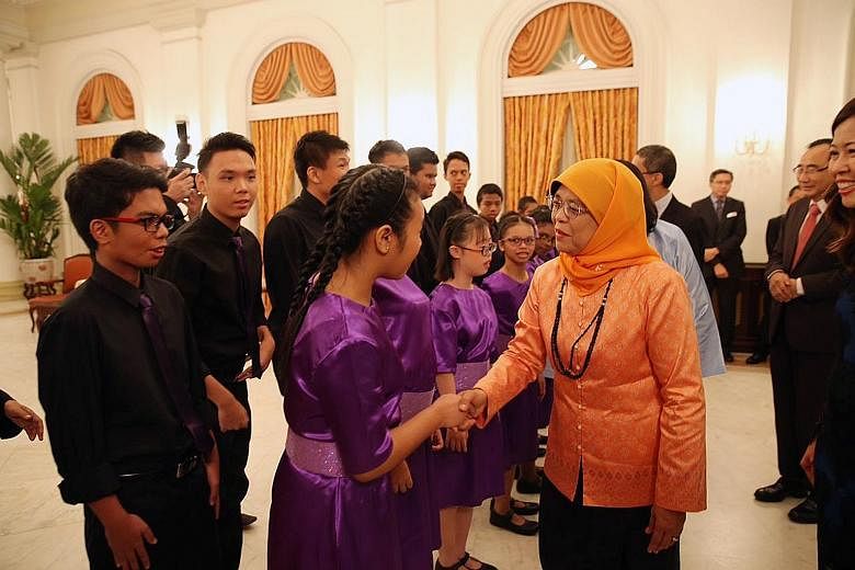 President Halimah Yacob meeting members of the MINDS Lee Kong Chian Gardens School choir before their performance at the Community Chest Awards ceremony at the Istana yesterday. She is the patron-in-chief of the National Council of Social Service, wh
