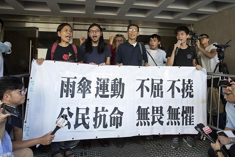 Pro-democracy activists gathering during a protest outside the High Court in Hong Kong yesterday. Supporters sang jailed pro-democracy leader Joshua Wong (above) a birthday song in the courtroom to mark his 21st birthday.