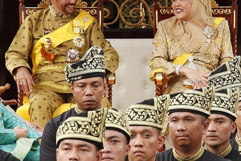 Brunei Sultan Hassanal Bolkiah and his wife, Raja Isteri Pengiran Anak Hajah Saleha, during a street procession to mark his Golden Jubilee in Bandar Seri Begawan on Oct 5.