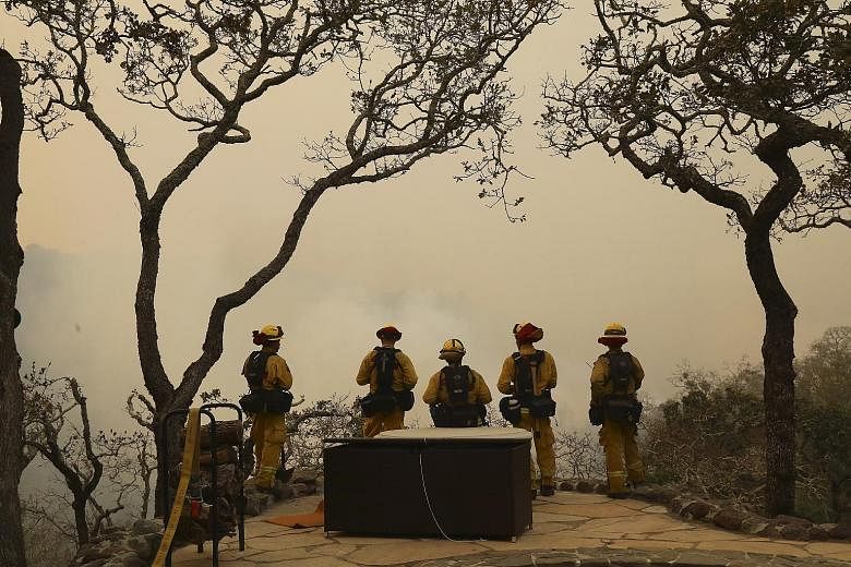 Firefighters in Sonoma County, California, facing a wall of smoke rising from the Norrbom fire burning across a valley on Wednesday. The county accounted for 17 of the North Bay fatalities, all from the Tubbs fire, which now ranks as California's dea