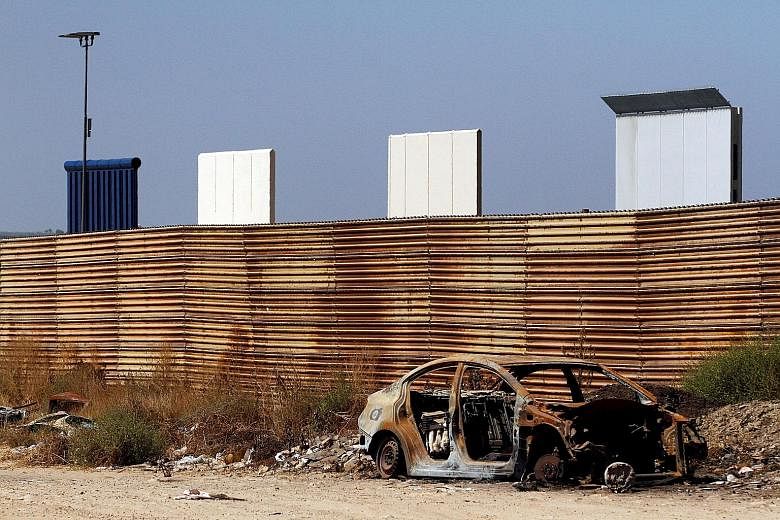 Prototypes for the United States' border wall with Mexico seen behind the current fence in Tijuana, Mexico, on Thursday.