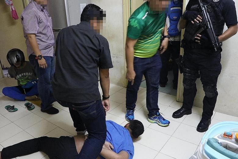 Malaysian counterterrorism officers arresting suspected Abu Sayyaf militants.