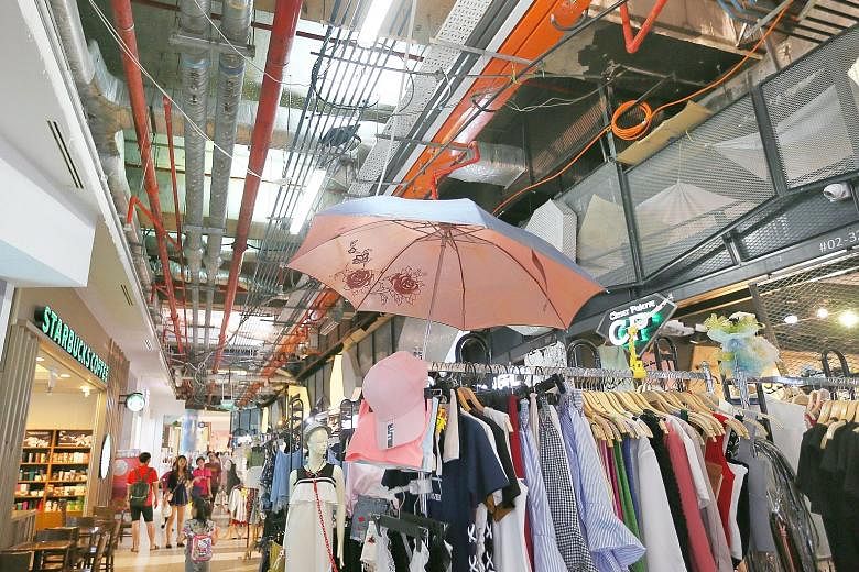 Some tenants at JCube have resorted to temporary measures, such as using umbrellas to shield their goods from water damage.