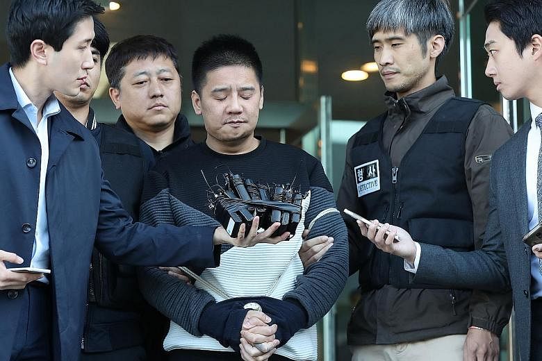 Murder suspect Lee Young Hak facing questions from reporters at the Chungang Police Station in Seoul last Friday.