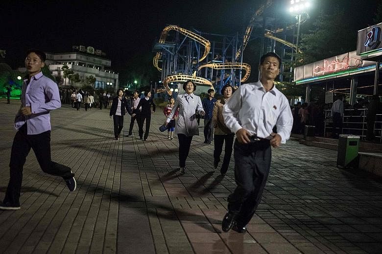 North Koreans at a fun fair in Pyongyang last month. On a recent trip to North Korea, the writer found the country to be galvanising its people to expect a nuclear war with the US. High school students march in the streets in military uniform daily t