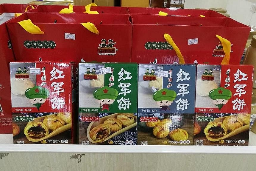 "Red Army" biscuits and souvenirs are widely available at shops in Jinggangshan. Visitors to Ciping taking pictures in the room that Mao Zedong stayed in during the early part of the Chinese Revolution. The former Red Army base is now a key tourism s