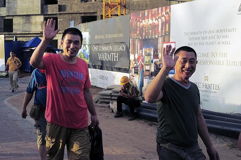 Chinese construction workers outside the Shangri-La hotel and apartment complex that is due for completion this year.
