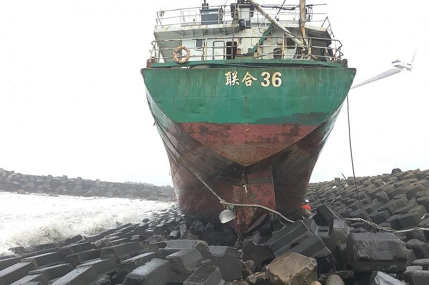 A Mongolian freighter run aground on the coast of Changhwa county, western Taiwan, due to Typhoon Khanun last Saturday. Tourists making the best of the wild weather yesterday at The Peak in Hong Kong, where the weather warning went down to the second