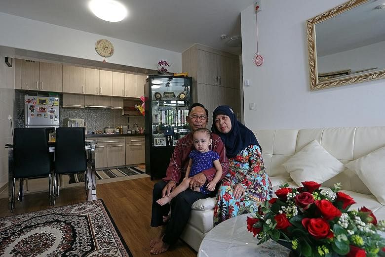 Mr Ahmad Mohammad Said, 66, with his wife Madam Norhati Nordin, 63, and their granddaughter Nurul Ilya Janah, 18 months, in their new studio flat. Above: Mr Heng Gee Choo, 64, and his wife Sie Gik Moi, 59, with their grandchildren Aden Cai, five, and