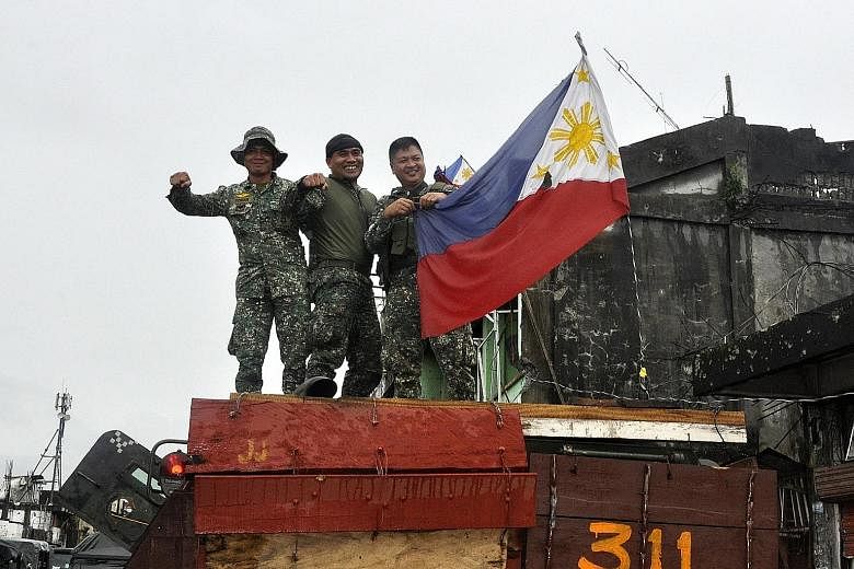 Philippine soldiers in the devastated city of Marawi yesterday. Half of Marawi lies in ruins and more than 1,000 militants, government troops and civilians have been killed, while about 400,000 people have been displaced.