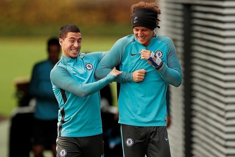 Chelsea's Eden Hazard (left) and David Luiz enjoying a light moment during a session at Cobham Training Centre in London yesterday ahead of their home Champions League match against Italian Serie A side Roma. An underwhelming start with three losses 