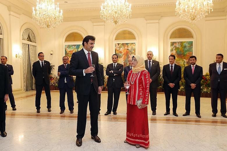 Qatari Emir Sheikh Tamim Bin Hamad al-Thani meeting President Halimah Yacob at a reception at the Istana yesterday. He thanked Madam Halimah for her interest in supporting the friendship between both countries. Sheikh Tamim with Prime Minister Lee Hs