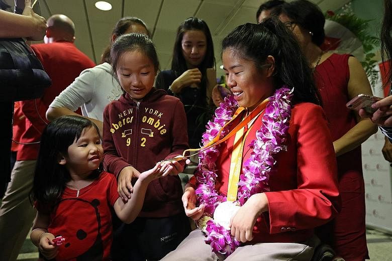 Rio Paralympics double champion Yip Pin Xiu showing her medals to her then four-and 10-year-old nieces Shernice Ang and Chew Xiu Wen at Changi Airport in September last year upon her return.